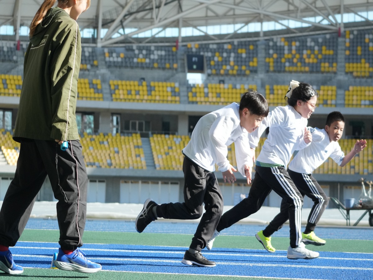 スタジアムで走る練習をする小学生